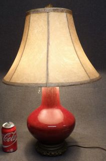 VINTAGE CHINESE SANG de BOEUF OXBLOOD PORCELAIN TABLE LAMP Vintage Chinese Sang de Boeuf Oxblood Porcelain Table Lamp. Lamp measures 24-1/2" tall x 8-1/2" wide. Shade is 16" wide. Condition is very good. No damage. Starting Bid $200. Auction Estimate $400 - $500.     