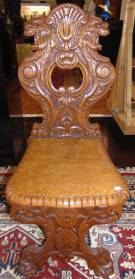 ANTIQUE ITALIAN CARVED OAK SGABELLO CHAIR Antique Italian Carved Oak Sgabello Chair. A Sgabello is a type of chair or stool typical of the Italian Renaissance. Measures 42-1/2" tall x 18" wide x 22" deep. Condition is very good with minimal wear. 1 small chip on back side (see close-up photo). Starting Bid $150. Auction Estimate $150 - $400. 